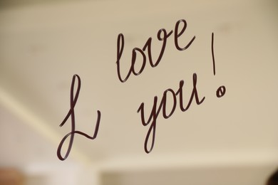 Photo of Handwritten text I Love You on mirror in room. Romantic message
