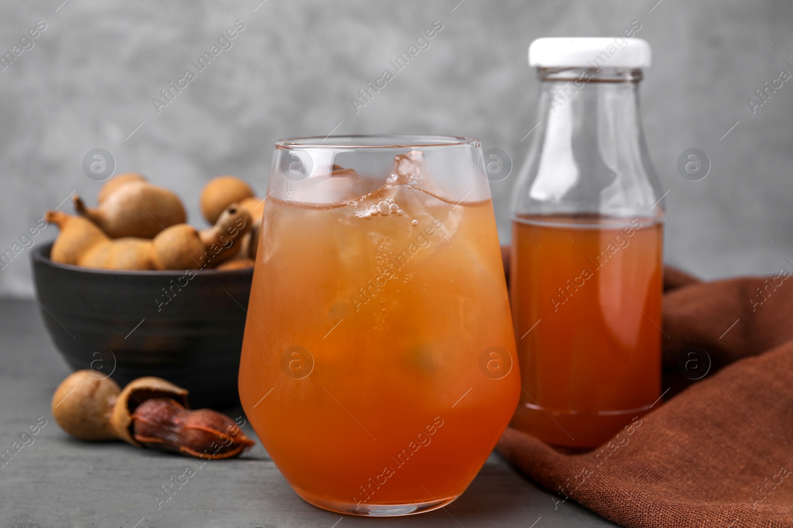 Photo of Freshly made tamarind juice on grey wooden table, closeup