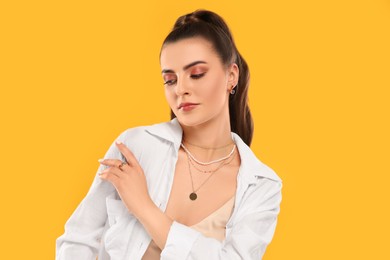 Photo of Beautiful woman with elegant jewelry on orange background