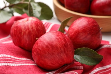 Fresh red apples with leaves on table, closeup