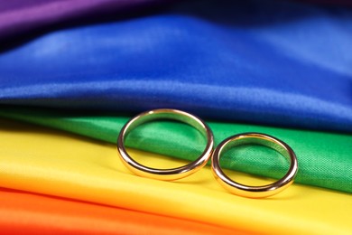 Wedding rings on rainbow LGBT flag, closeup