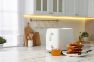 Photo of Breakfast served in kitchen. Toaster, crunchy bread and honey on white marble table. Space for text
