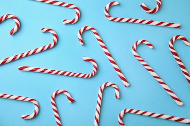 Photo of Flat lay composition with candy canes on light blue background