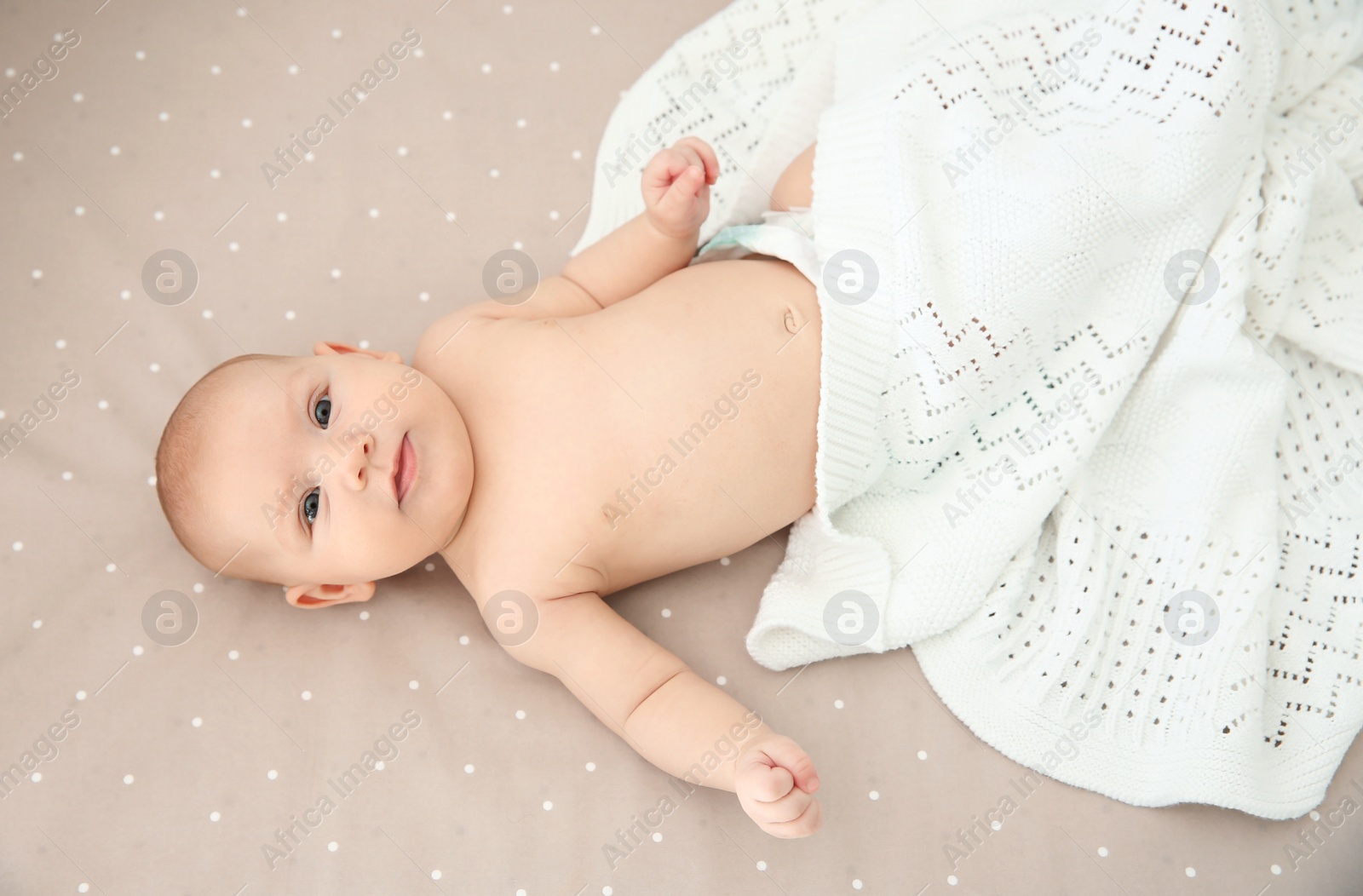 Photo of Adorable baby girl lying in bed, top view