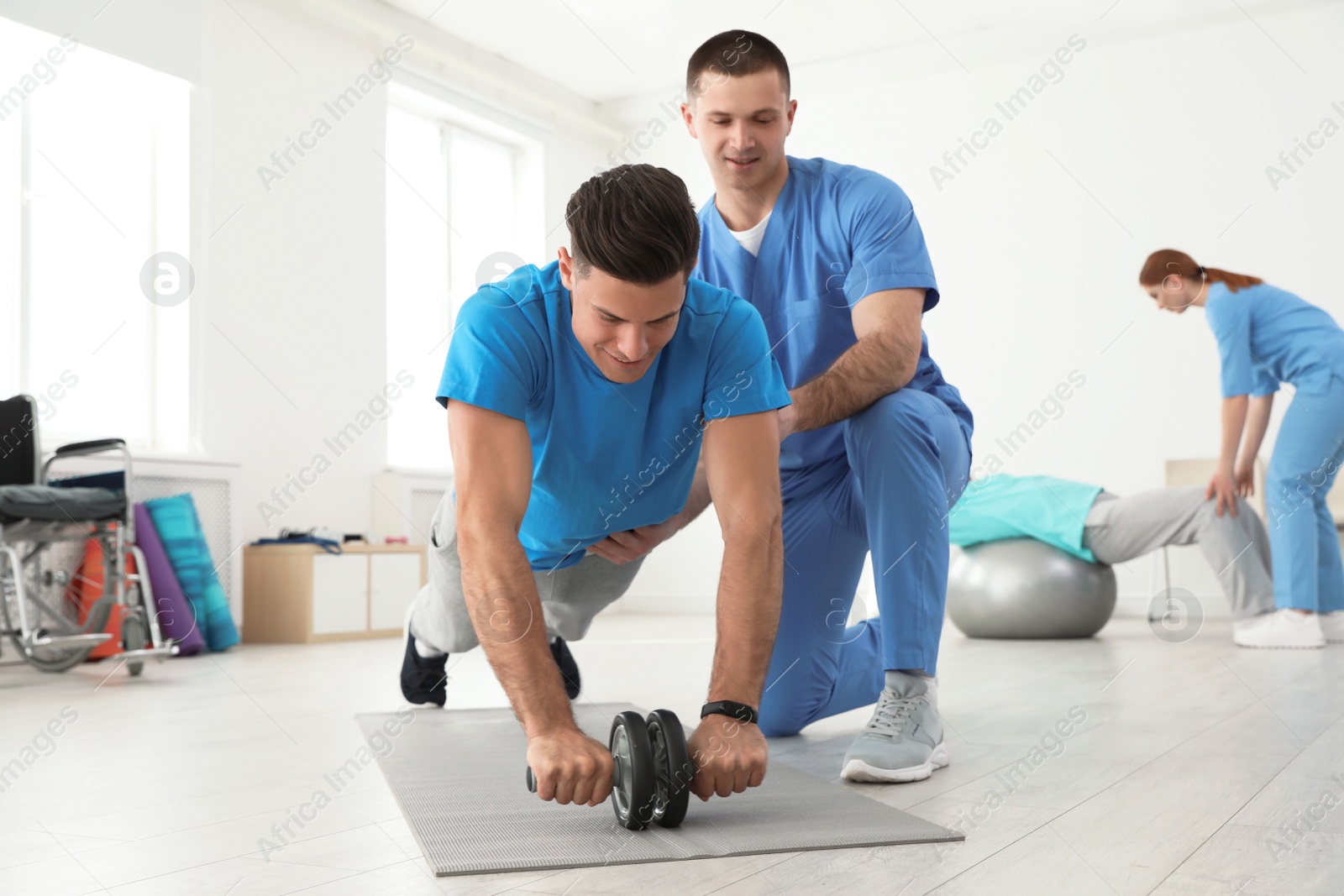 Photo of Professional physiotherapist working with male patient in rehabilitation center