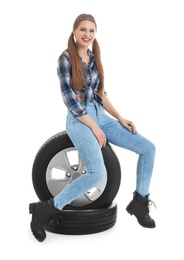 Photo of Young woman in seductive outfit with car tires on white background