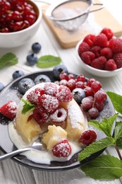 Delicious vanilla fondant served with fresh berries on white wooden table, closeup