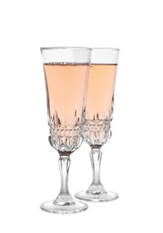 Photo of Glasses of sparkling rose champagne isolated on white