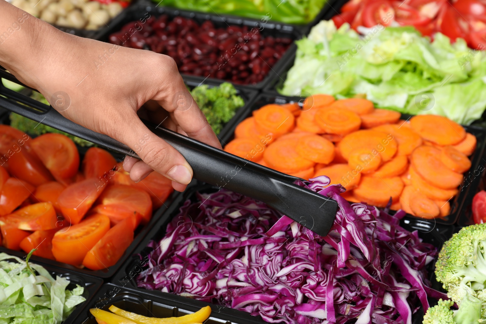 Photo of Young woman taking chopped red cabbage from salad bar, closeup