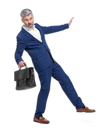 Photo of Mature businessman with briefcase posing on white background