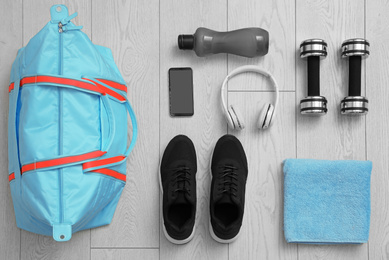 Flat lay composition with sports bag on wooden background