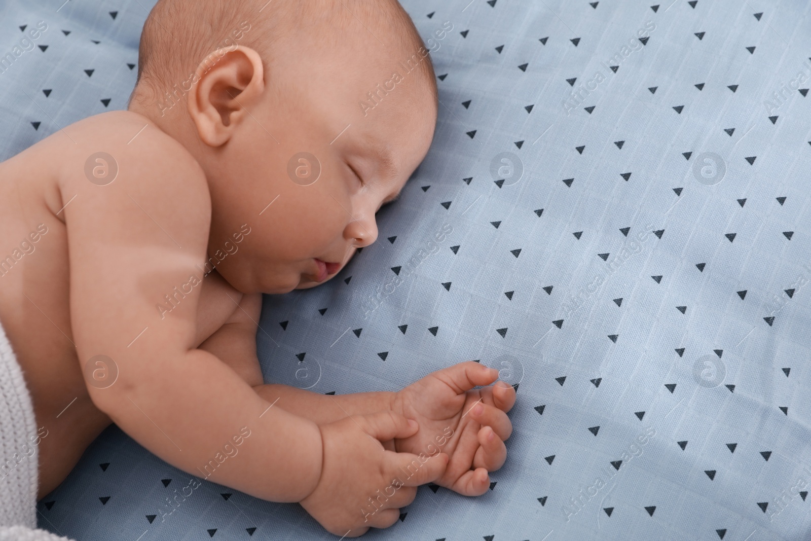 Photo of Cute little baby sleeping on bed, above view. Space for text