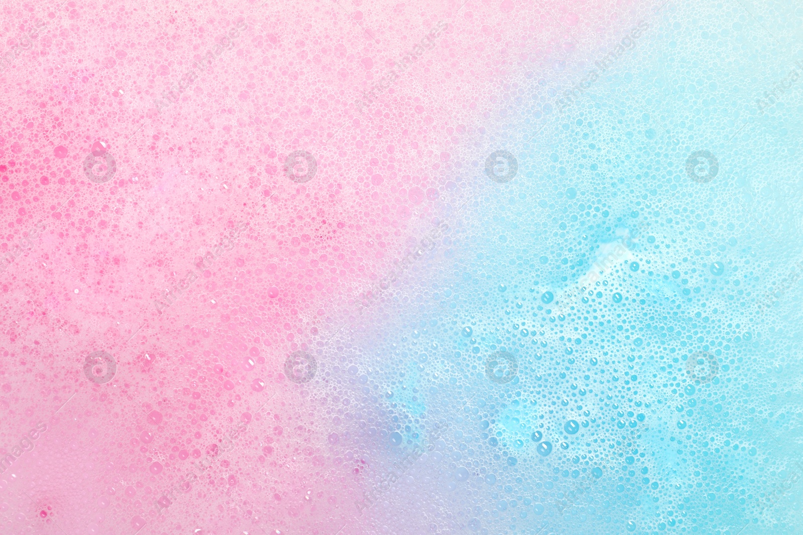 Photo of Colorful foam after dissolving bath bomb in water, closeup