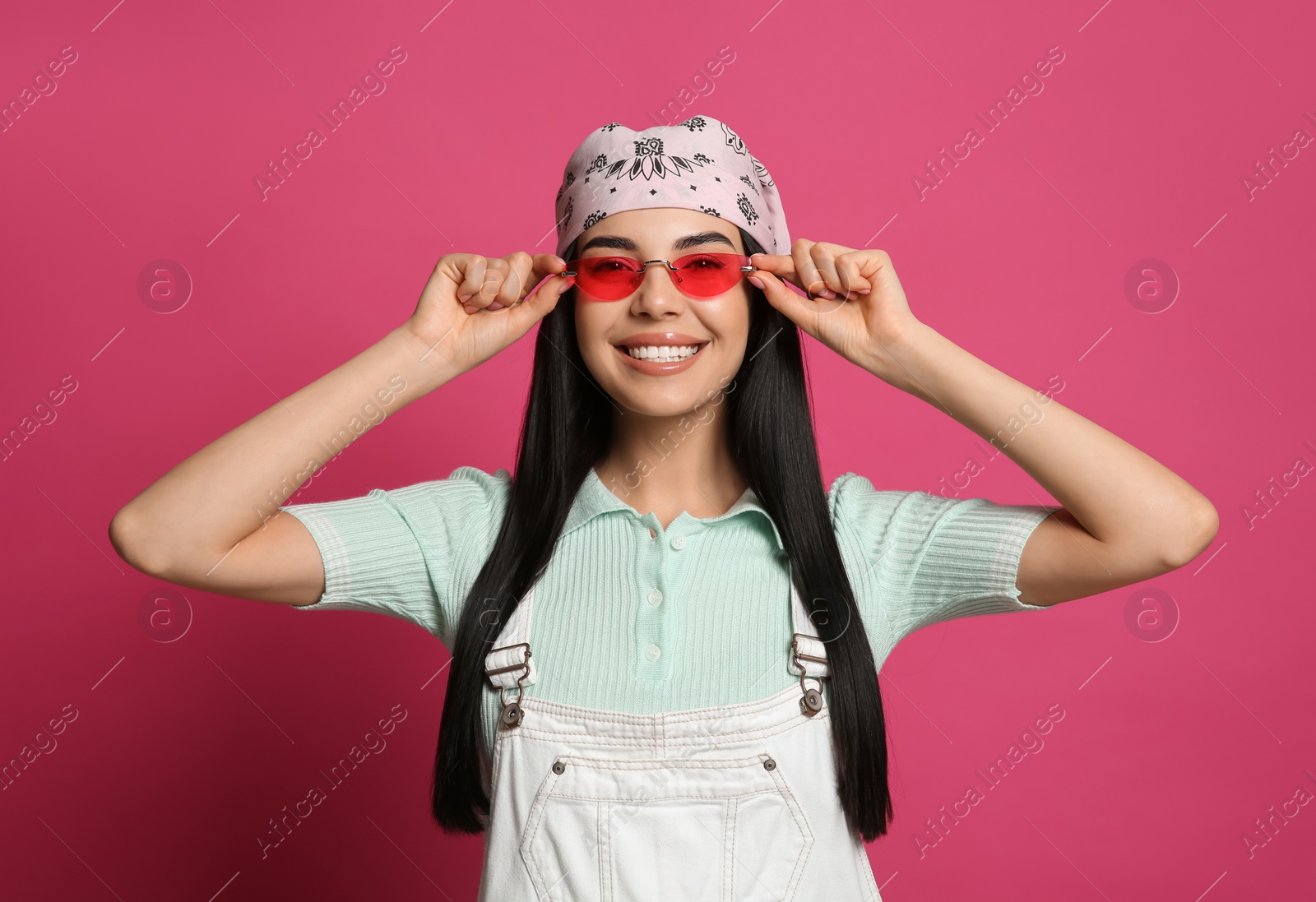 Photo of Young woman wearing stylish bandana and sunglasses on pink background