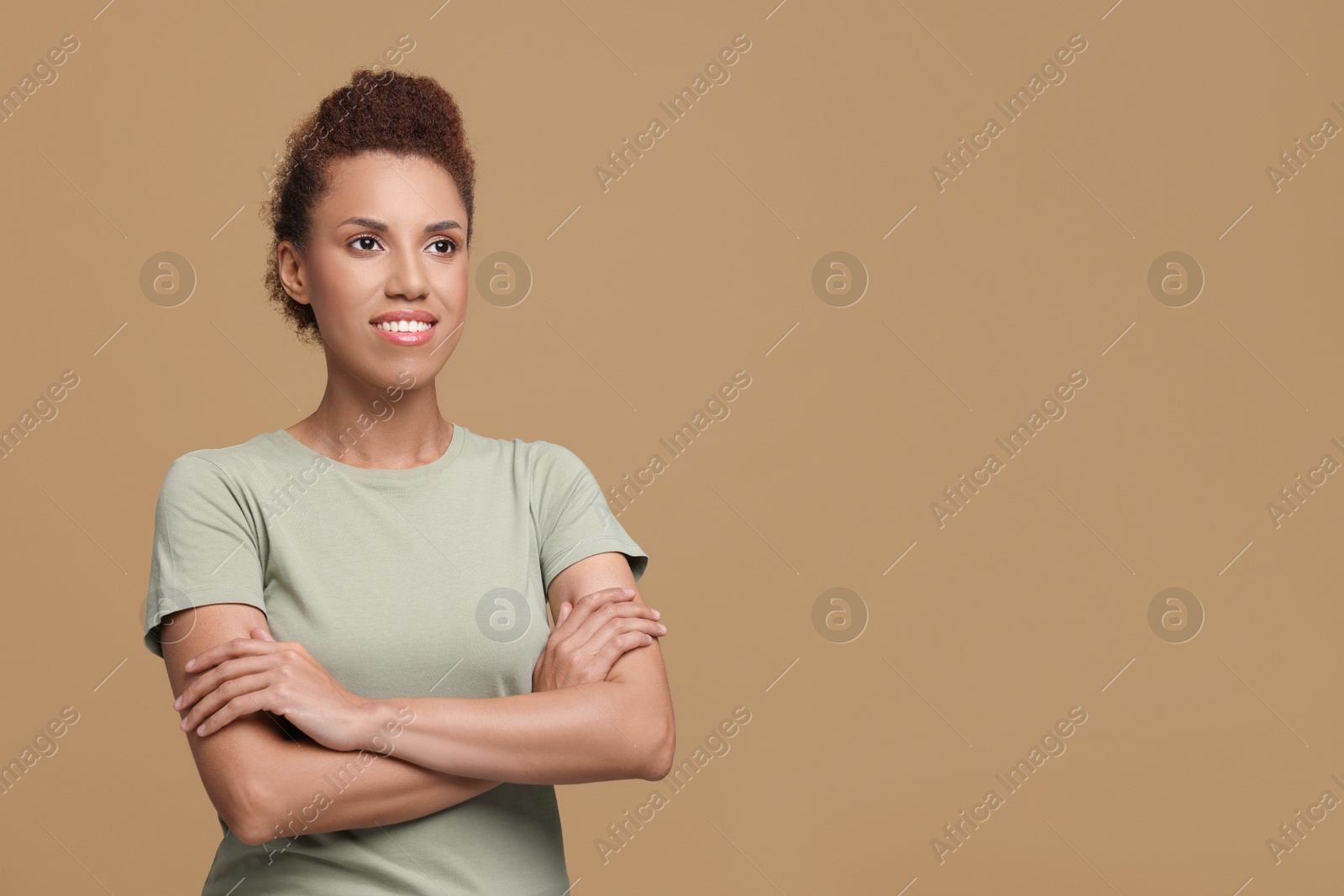 Photo of Portrait of beautiful young woman on light brown background. Space for text