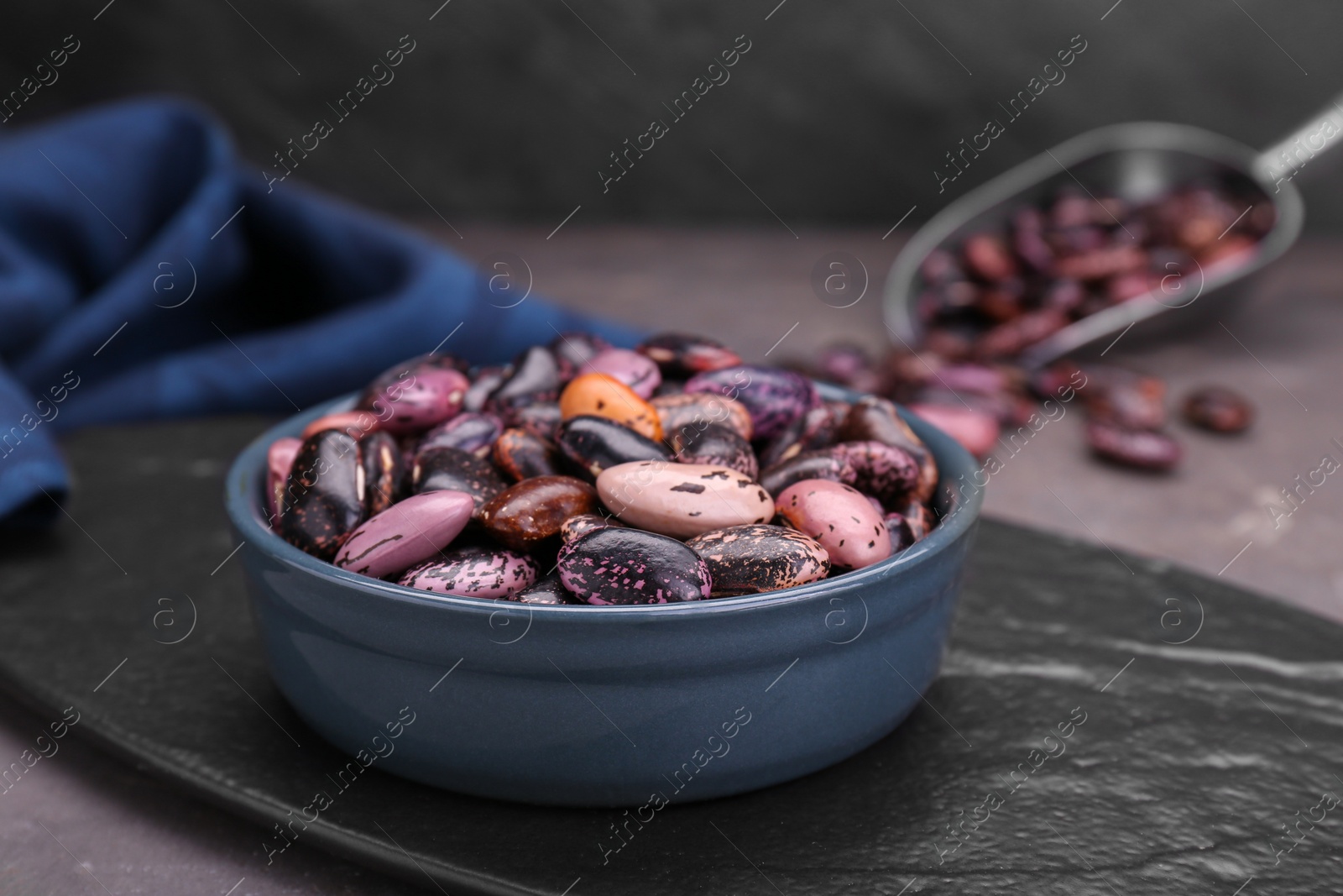 Photo of Bowl with dry kidney beans on table, closeup