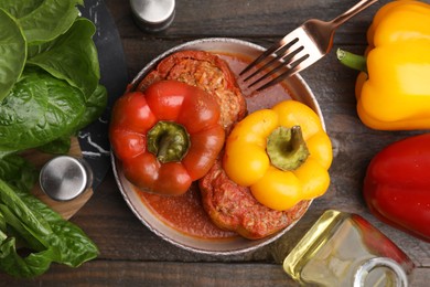 Photo of Delicious stuffed bell peppers served on wooden table, flat lay