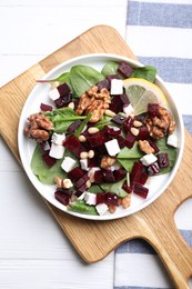 Photo of Delicious beet salad served on white wooden table, top view