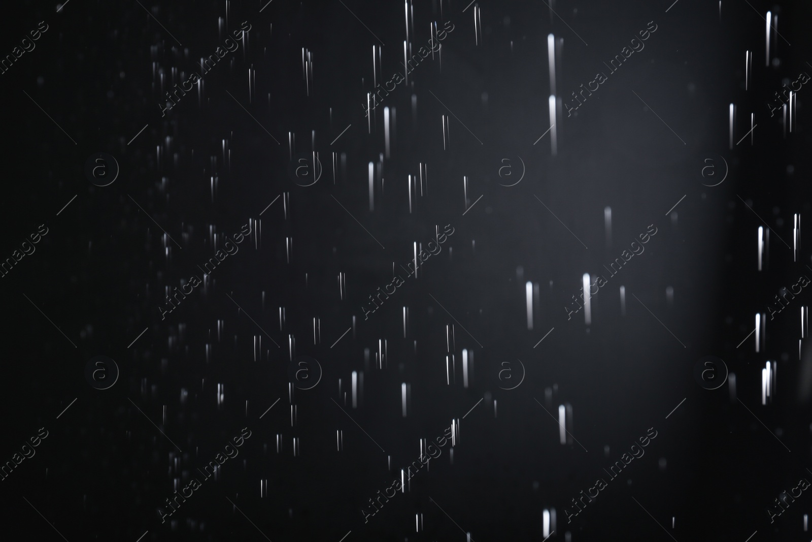 Photo of Water drops falling on black background. Rainy weather