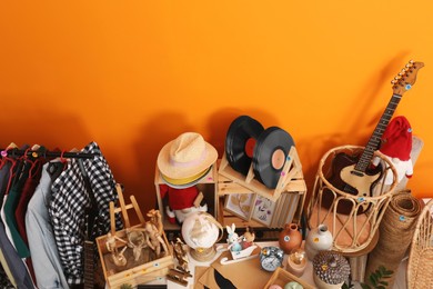 Many different stuff near orange wall, above view. Garage sale