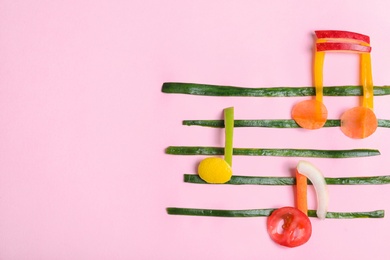 Photo of Musical notes made of fruits and vegetables on color background, top view. Space for text