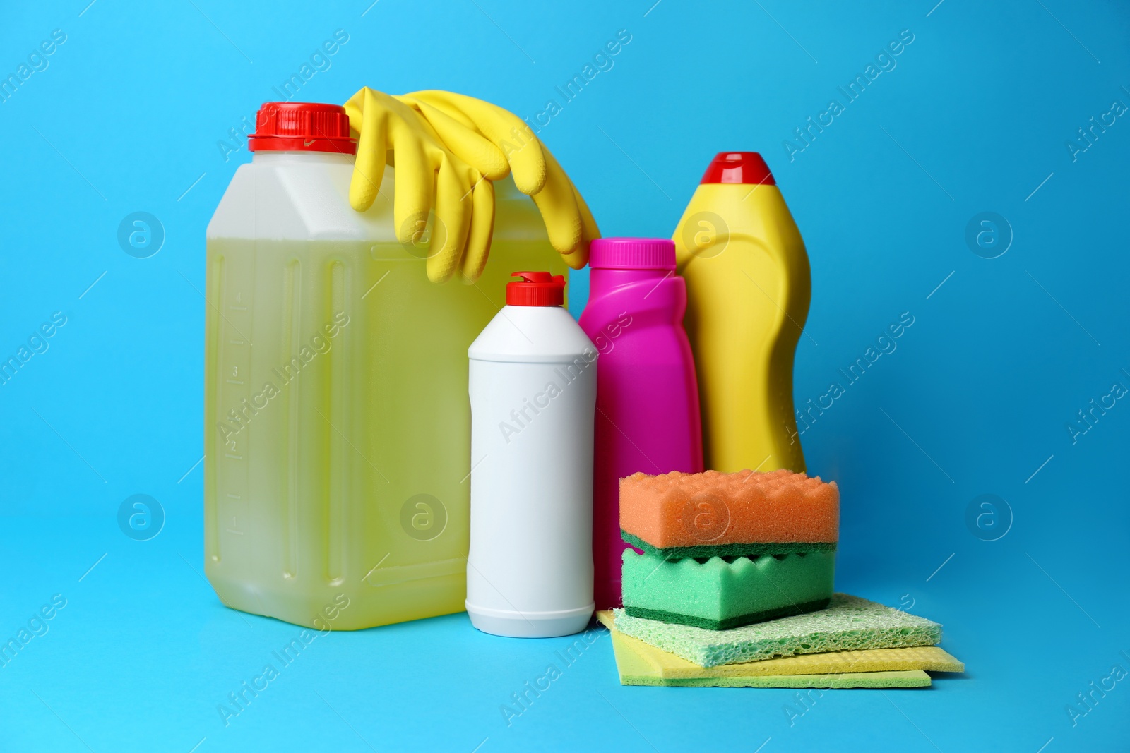 Photo of Cleaning supplies and tools on light blue background