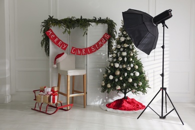 Photo of Beautiful photo zone with professional equipment and decorated Christmas tree