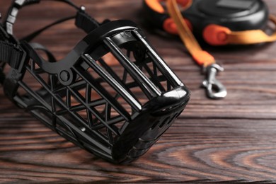 Black plastic dog muzzle on wooden table, closeup