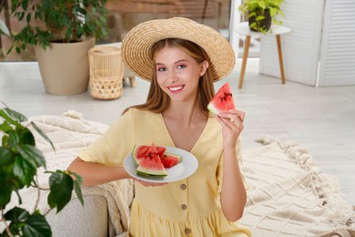Photo of Beautiful teenage girl with slices of watermelon at home