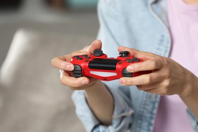 Photo of Woman playing video game with controller at home, closeup. Space for text