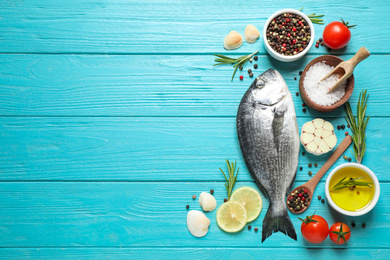 Photo of Flat lay composition with raw dorada fish on light blue wooden table, space for text