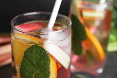 Photo of Glass of tasty rhubarb cocktail with lemon, closeup. Space for text