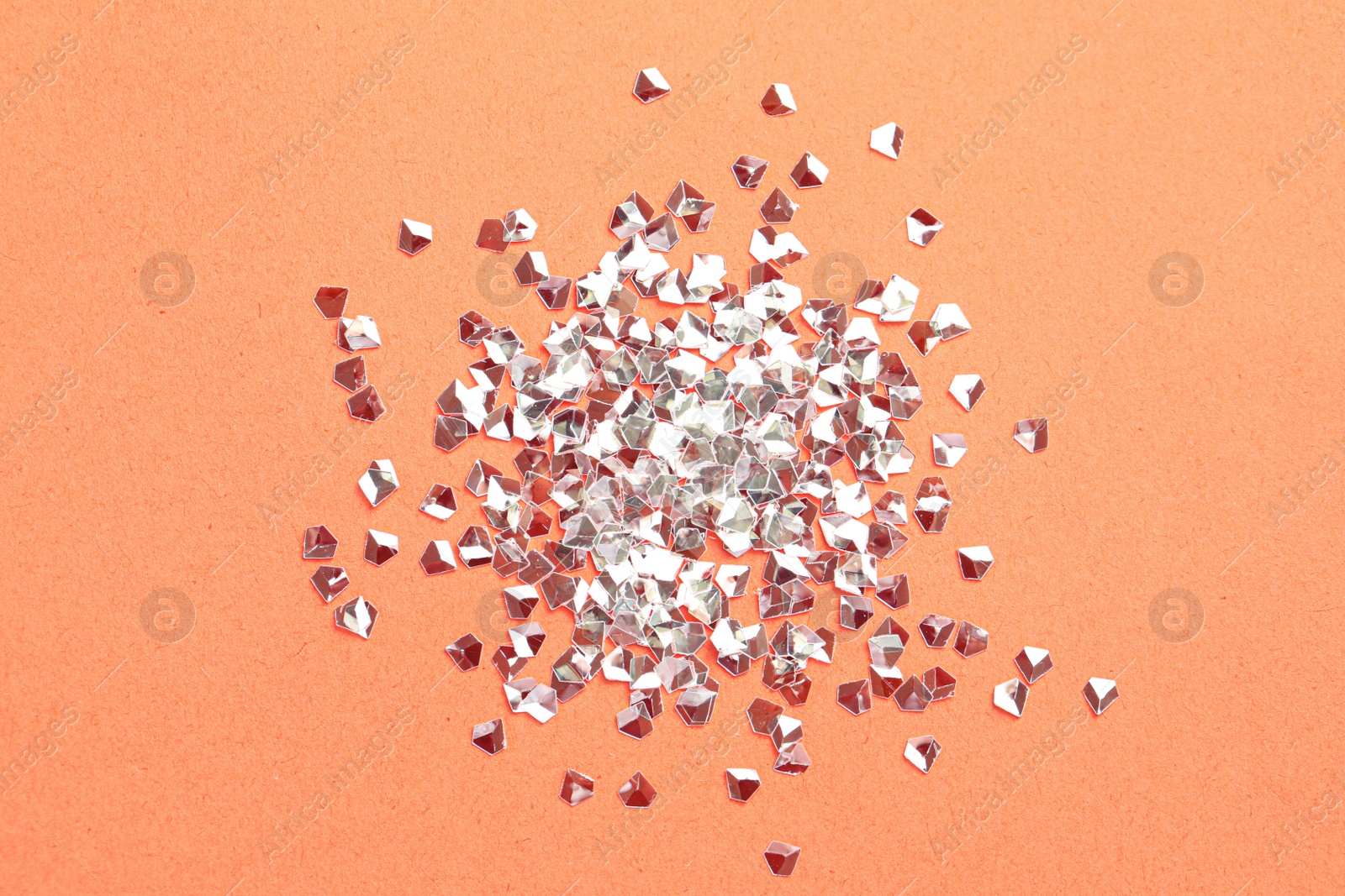 Photo of Pile of shiny glitter on pale pink background, flat lay