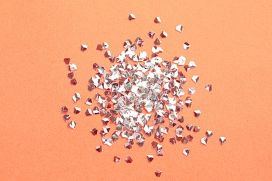 Photo of Pile of shiny glitter on pale pink background, flat lay