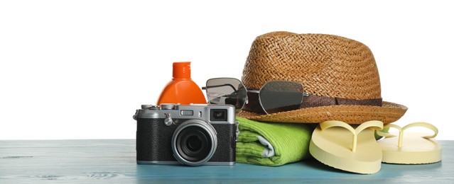 Different beach objects on turquoise wooden table against white background