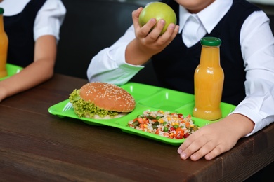 Photo of Children with healthy food for school lunch at desk, closeup