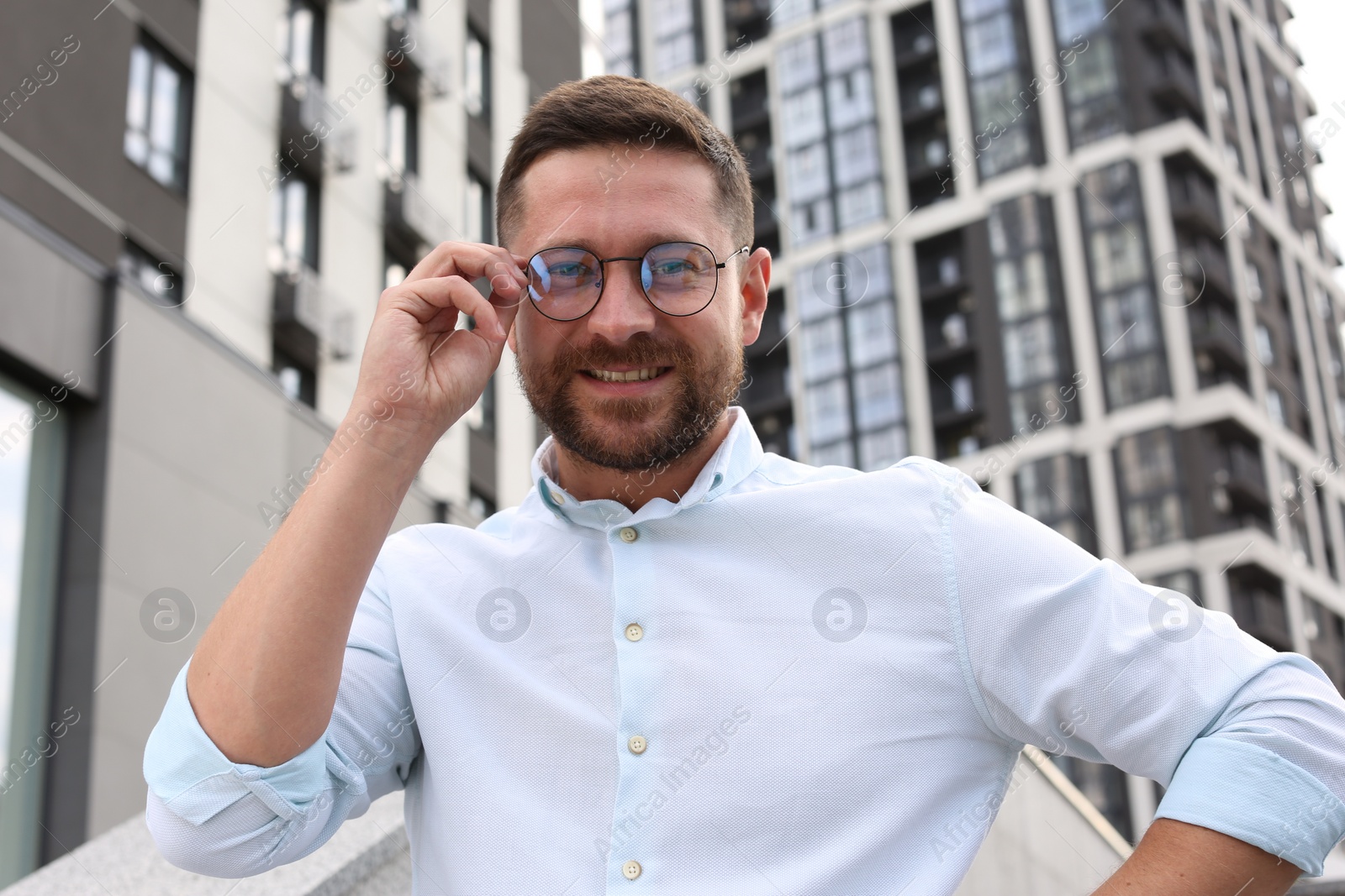 Photo of Portrait of handsome bearded man in glasses outdoors