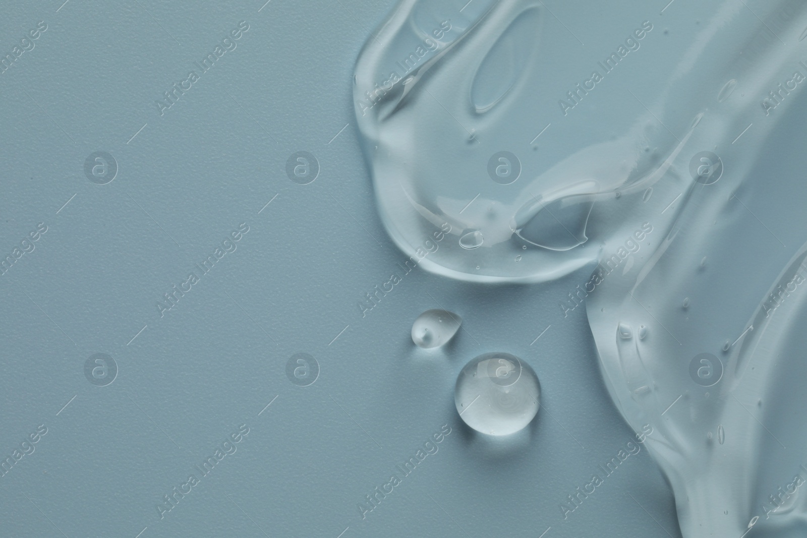 Photo of Clear cosmetic gel on light blue background, top view. Space for text