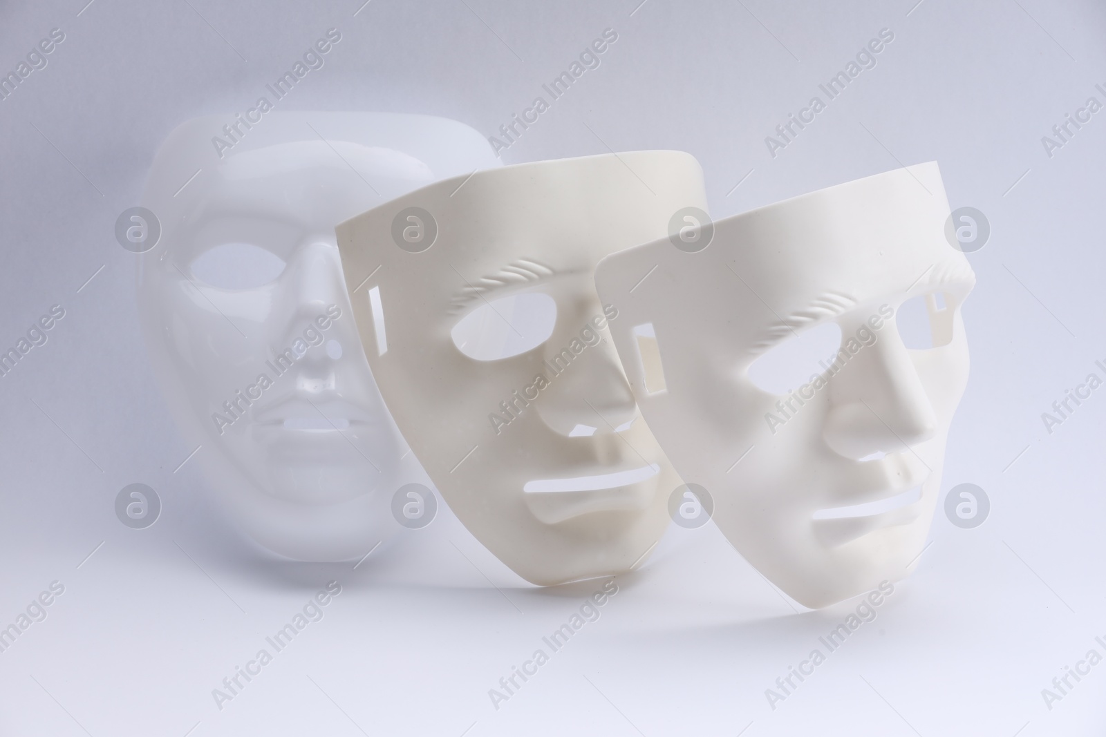 Photo of Plastic face masks on white background. Theatrical performance