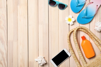 Photo of Flat lay composition with beach objects and mobile phone on wooden background