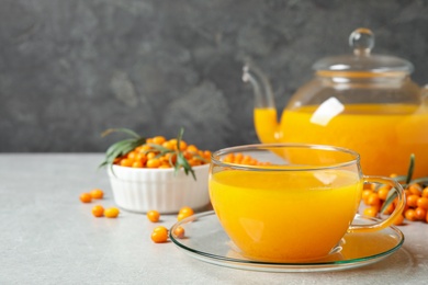 Photo of Fresh sea buckthorn tea on light table. Space for text