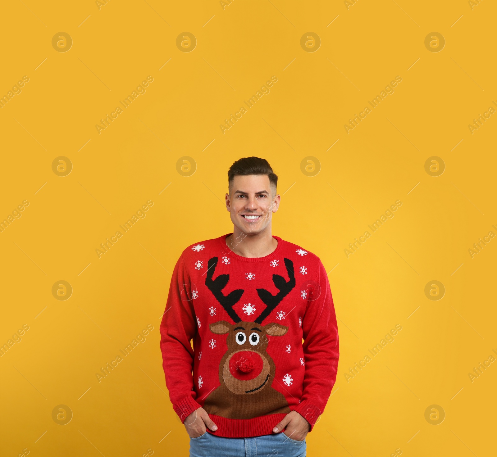 Photo of Handsome man in Christmas sweater on yellow background