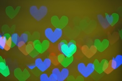Photo of Blurred view of beautiful heart shaped lights on color background