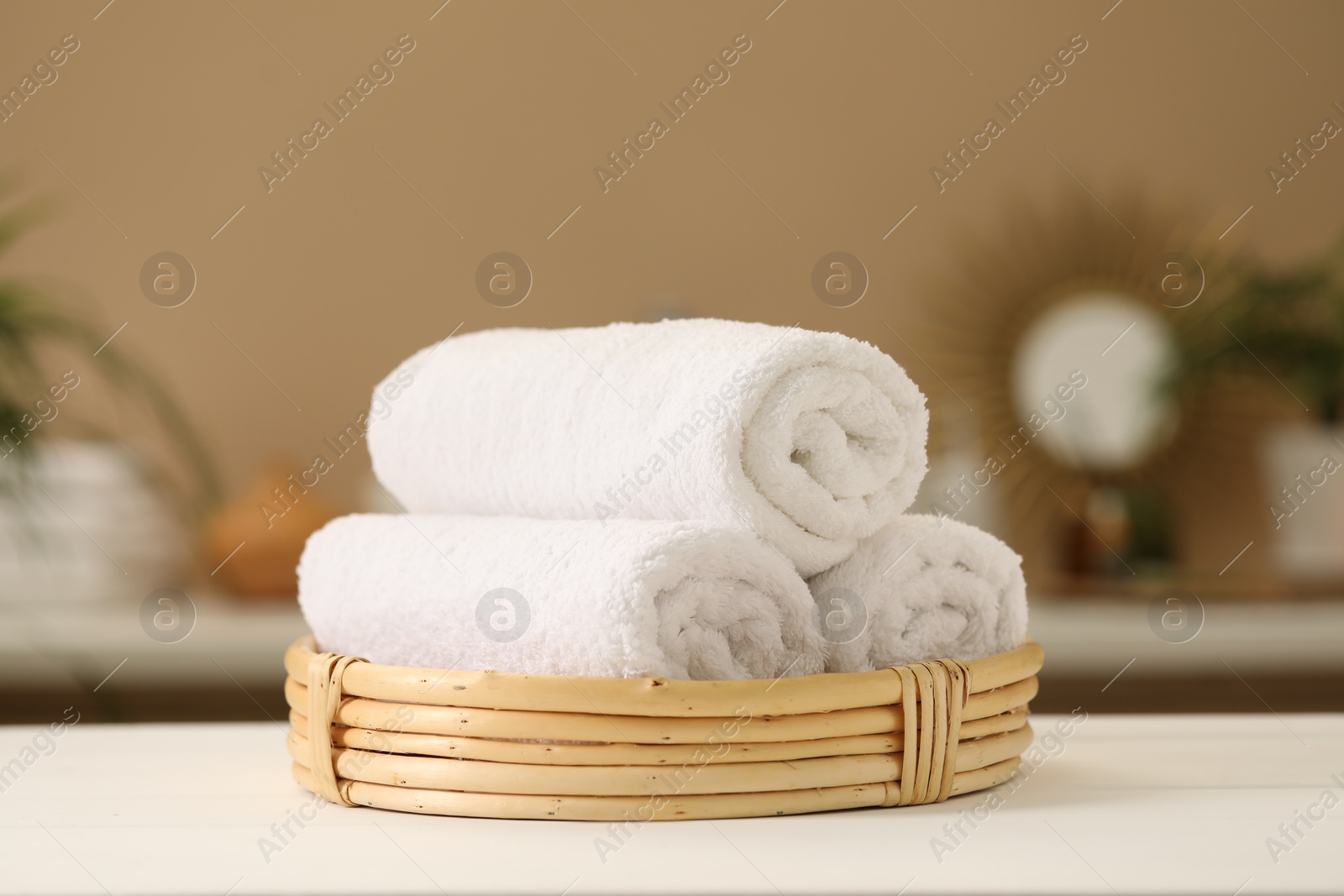 Photo of Spa composition. Rolled towels on white table indoors