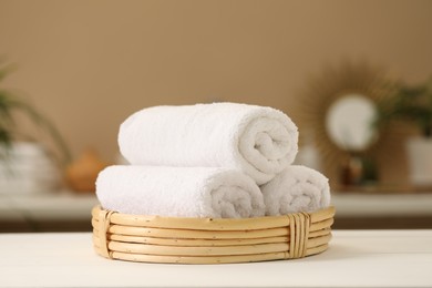Photo of Spa composition. Rolled towels on white table indoors