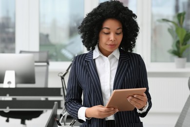 Young businesswoman using tablet in modern office