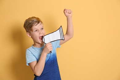 Photo of Cute little boy with paper megaphone on color background