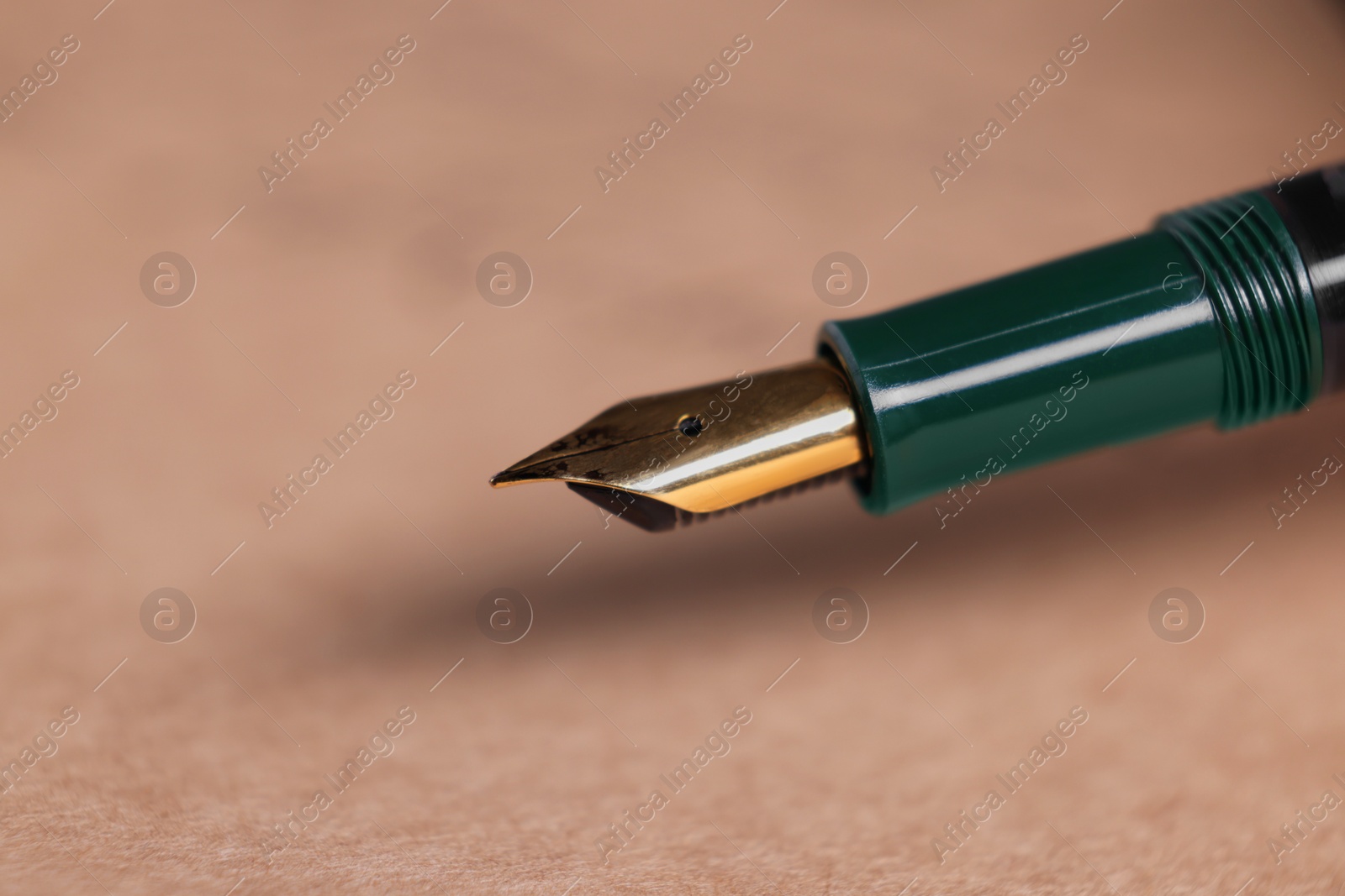 Photo of Elegant fountain pen on sheet of paper, closeup. Space for text