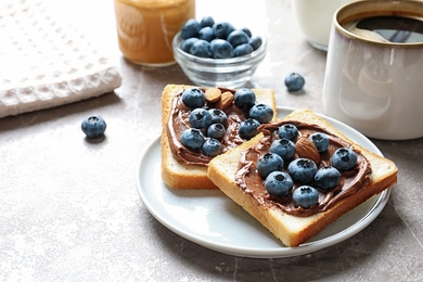 Photo of Toast bread with blueberries and chocolate paste on table