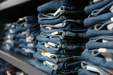 Collection of modern jeans on shelf in shop, closeup